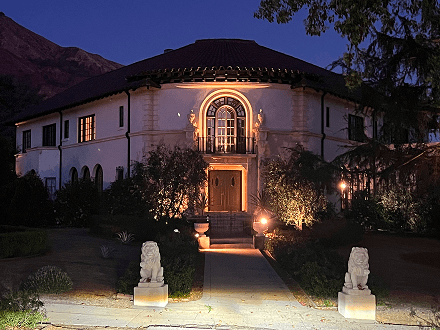 A large white house with lights on the front of it.